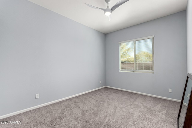 spare room featuring baseboards, a ceiling fan, and carpet