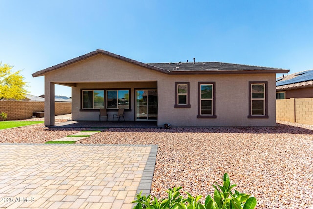 back of house with a fenced backyard, a patio, and stucco siding