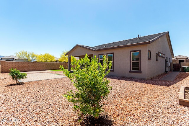 rear view of property with a patio, a fenced backyard, and stucco siding