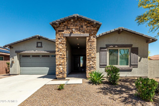view of front of home with a tiled roof, an attached garage, driveway, and stucco siding
