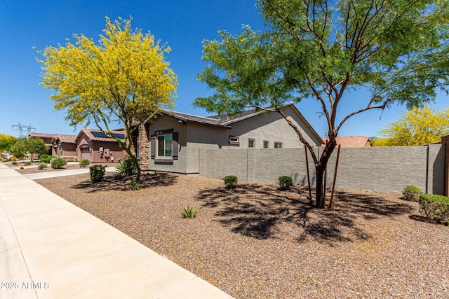 view of side of property with fence and stucco siding