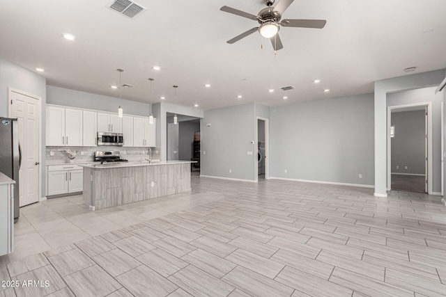 kitchen featuring light countertops, stainless steel appliances, open floor plan, and visible vents