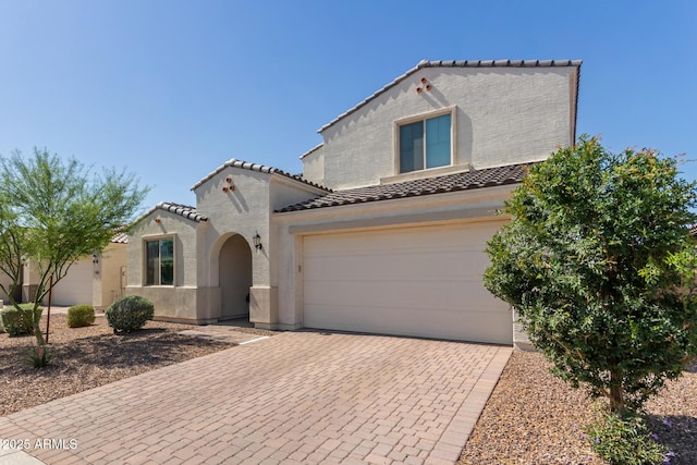 5330 W Thresher Way, Laveen, AZ 85339 - mediterranean / spanish house with a tile roof, stucco siding, decorative driveway, and a garage