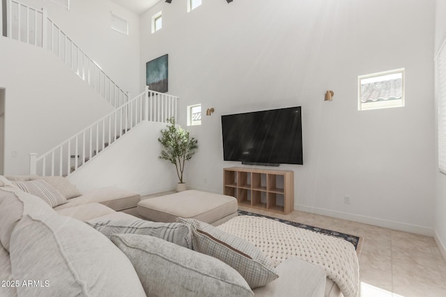 5330 W Thresher Way, Laveen, AZ 85339 - living room with healthy amount of natural light, stairway, a high ceiling, and baseboards