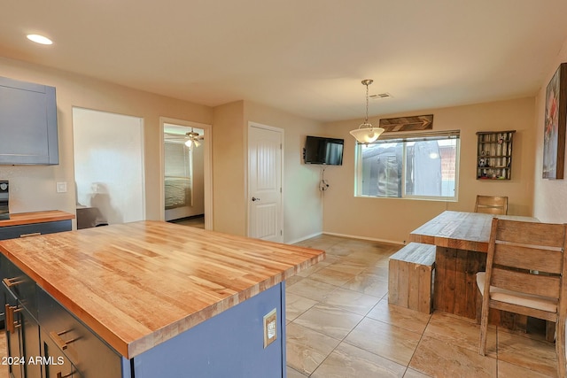 kitchen with butcher block counters, a kitchen island, and decorative light fixtures