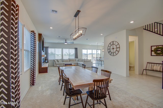 dining space featuring ceiling fan with notable chandelier and light tile patterned flooring