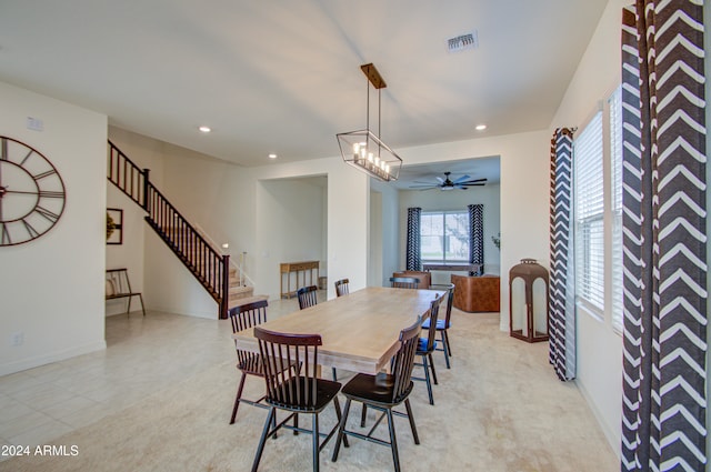 carpeted dining room with ceiling fan with notable chandelier