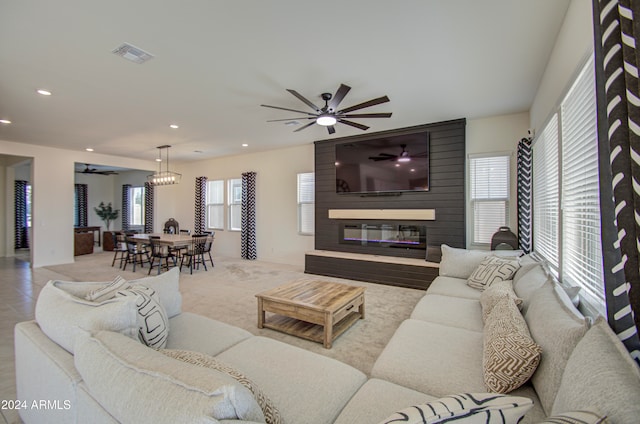 living room with a wealth of natural light, ceiling fan, and a large fireplace