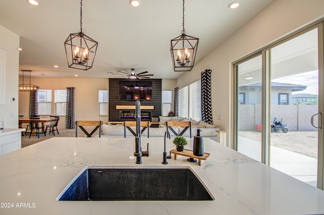 kitchen featuring sink, light stone countertops, and decorative light fixtures