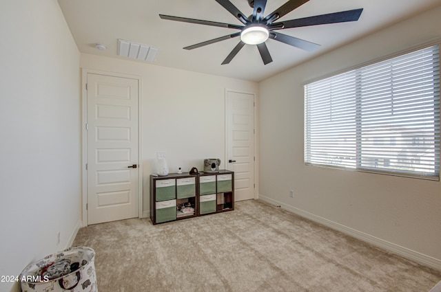 interior space featuring ceiling fan and light colored carpet