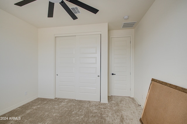 unfurnished bedroom featuring a closet, light carpet, and ceiling fan