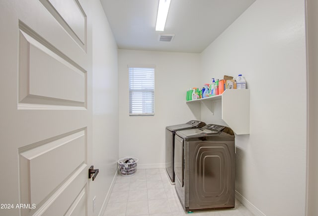 clothes washing area featuring washer and clothes dryer and light tile patterned flooring