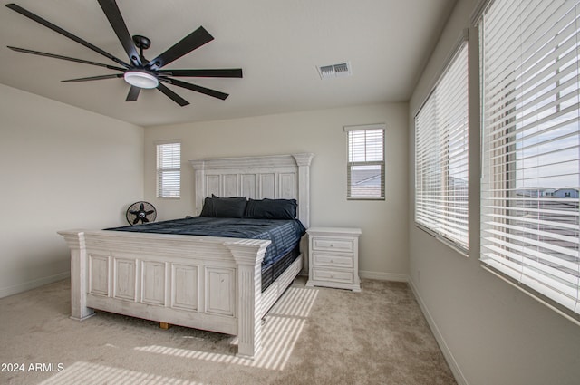 carpeted bedroom with ceiling fan and multiple windows