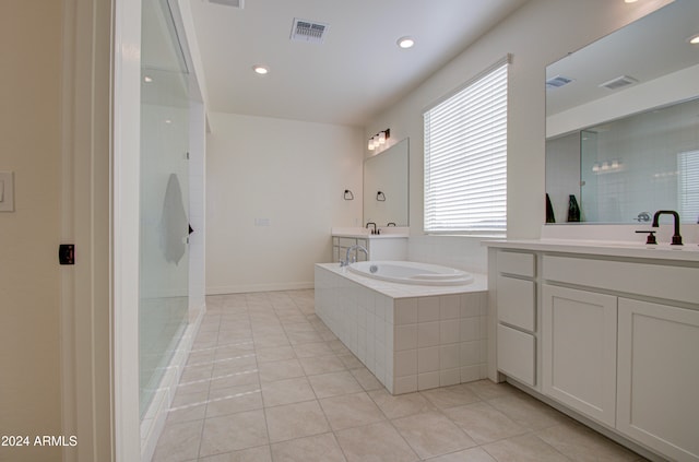 bathroom featuring plus walk in shower, vanity, and tile patterned floors