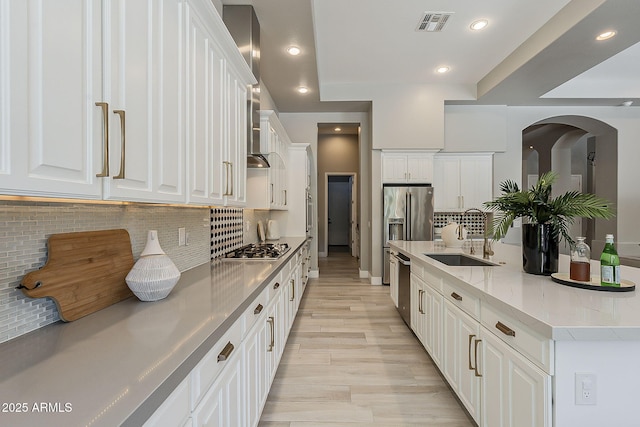 kitchen with a sink, tasteful backsplash, appliances with stainless steel finishes, and white cabinets