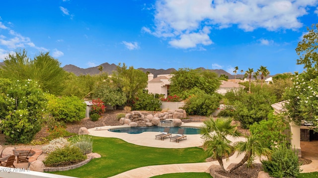 exterior space featuring a patio area, a mountain view, and a yard