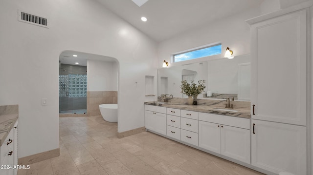 bathroom featuring plus walk in shower, tile patterned floors, and vanity