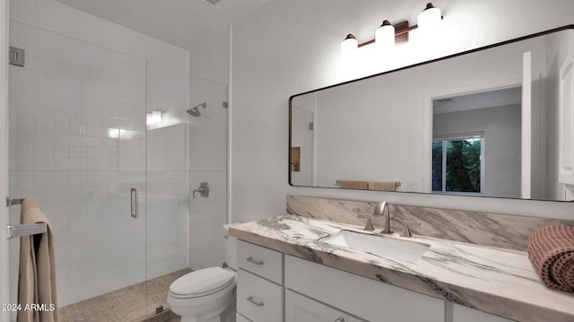 bathroom with an enclosed shower, vanity, and toilet