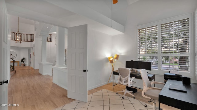 office area with light hardwood / wood-style floors, a chandelier, and ornate columns