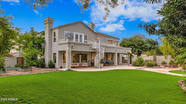 back of house featuring a balcony, a lawn, and a patio