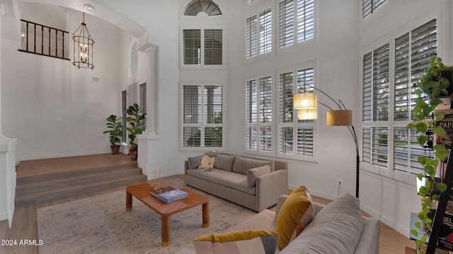 living room featuring a notable chandelier, a high ceiling, and hardwood / wood-style floors