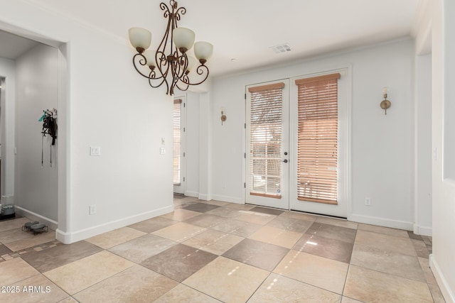 unfurnished dining area featuring ornamental molding, french doors, and an inviting chandelier