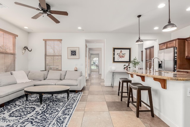 living room with ceiling fan, light tile patterned floors, plenty of natural light, and sink