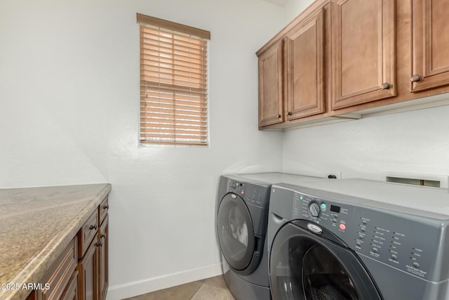 laundry room with light tile patterned floors, separate washer and dryer, and cabinets