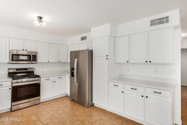 kitchen featuring visible vents, appliances with stainless steel finishes, white cabinets, and light countertops