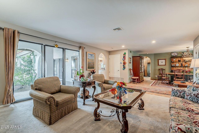 living area featuring visible vents, arched walkways, and recessed lighting