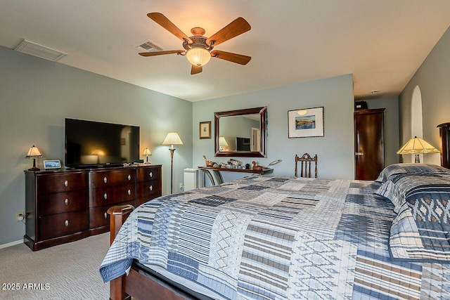 carpeted bedroom featuring baseboards, arched walkways, visible vents, and a ceiling fan