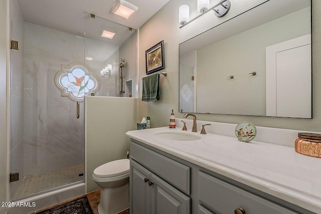 bathroom featuring a stall shower, vanity, and toilet