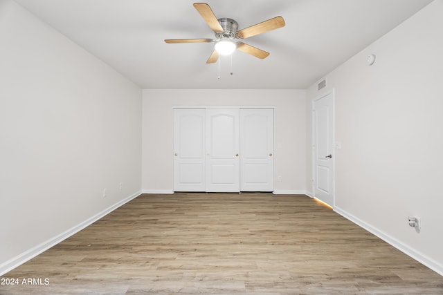unfurnished bedroom with ceiling fan, light hardwood / wood-style floors, and a closet