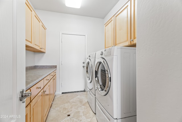 laundry area with cabinets, light tile patterned floors, and separate washer and dryer