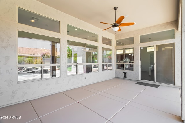 unfurnished sunroom with ceiling fan and a wealth of natural light