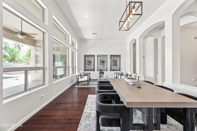 dining space featuring ceiling fan with notable chandelier and dark hardwood / wood-style flooring