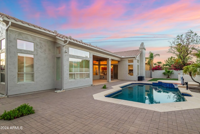 pool at dusk with a patio