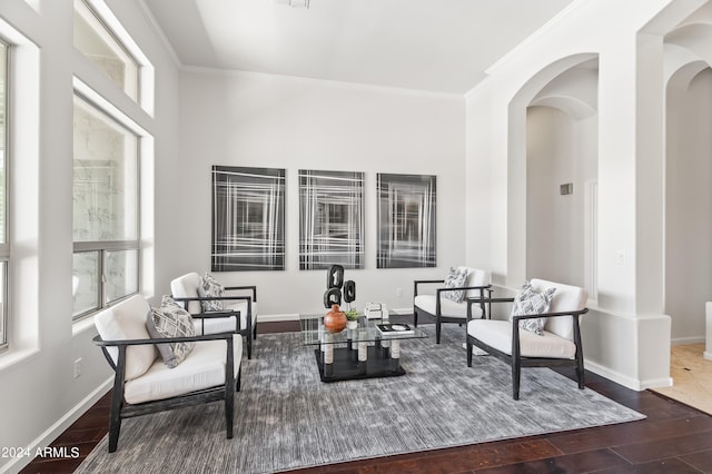 living area with hardwood / wood-style flooring and ornamental molding