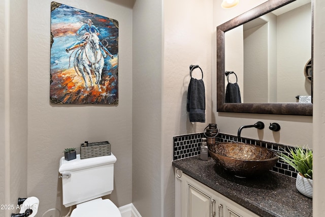 bathroom featuring vanity, toilet, and decorative backsplash