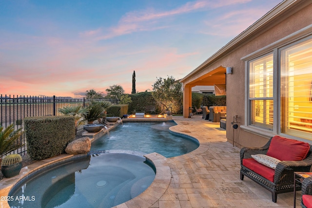 pool at dusk with an in ground hot tub, pool water feature, an outdoor living space, and a patio area