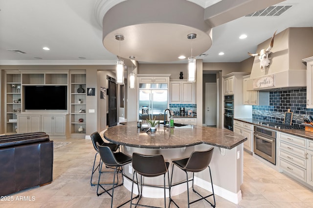 kitchen featuring pendant lighting, sink, a kitchen breakfast bar, stainless steel appliances, and a spacious island