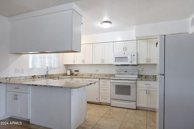 kitchen with light stone countertops, white appliances, light tile patterned floors, kitchen peninsula, and white cabinetry