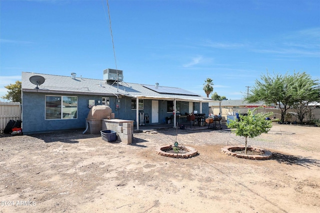 back of property featuring a fire pit, a patio, and central AC