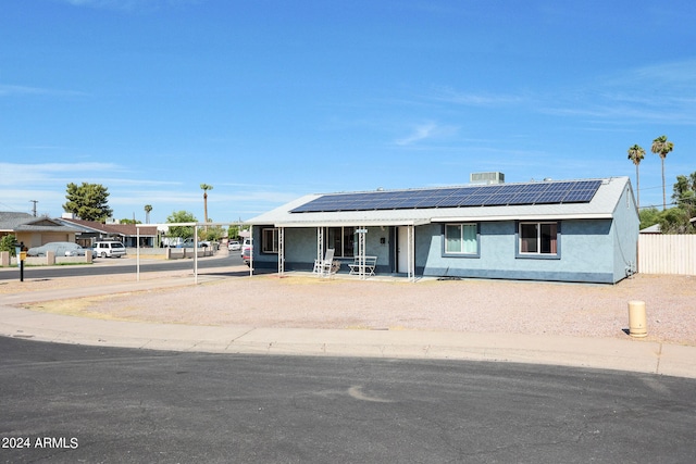 view of front facade featuring solar panels and a porch