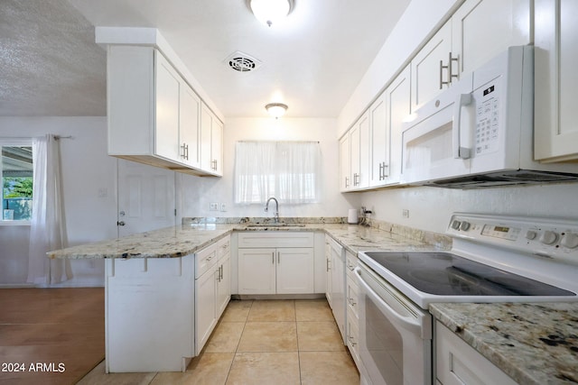 kitchen with sink, light stone countertops, white appliances, and white cabinets