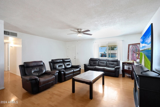 living room featuring a textured ceiling, light hardwood / wood-style flooring, and ceiling fan