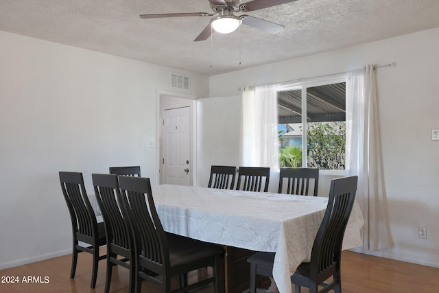 dining space featuring a textured ceiling, ceiling fan, and hardwood / wood-style flooring