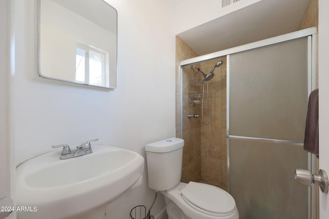 bathroom with walk in shower, toilet, and sink