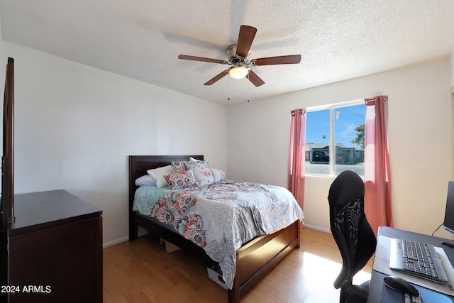 bedroom featuring a textured ceiling, ceiling fan, and hardwood / wood-style floors