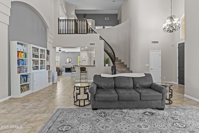 1244 W Straford Ave, Gilbert, AZ 85233 - living area featuring a fireplace, a chandelier, stairway, a high ceiling, and baseboards